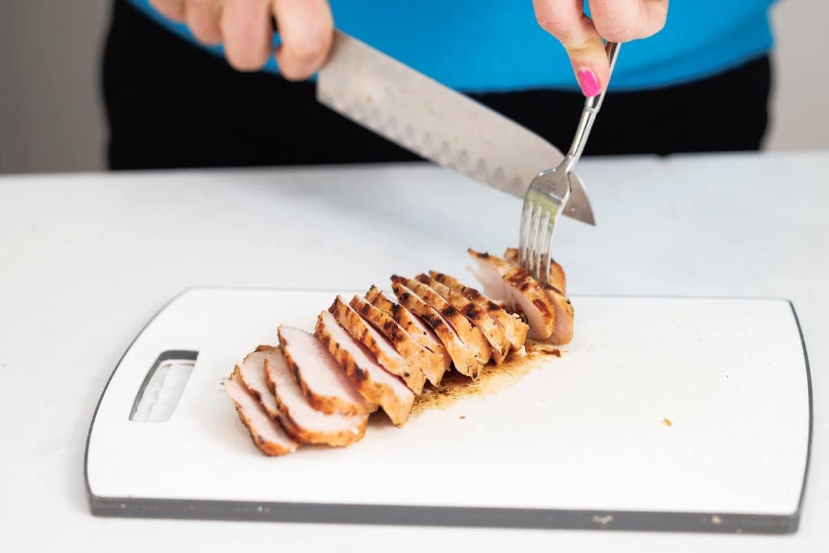 Liz slicing grilled turkey tenderloins with a sharp knife.