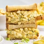 A stacked egg salad sandwich filled with creamy dill pickle egg salad.