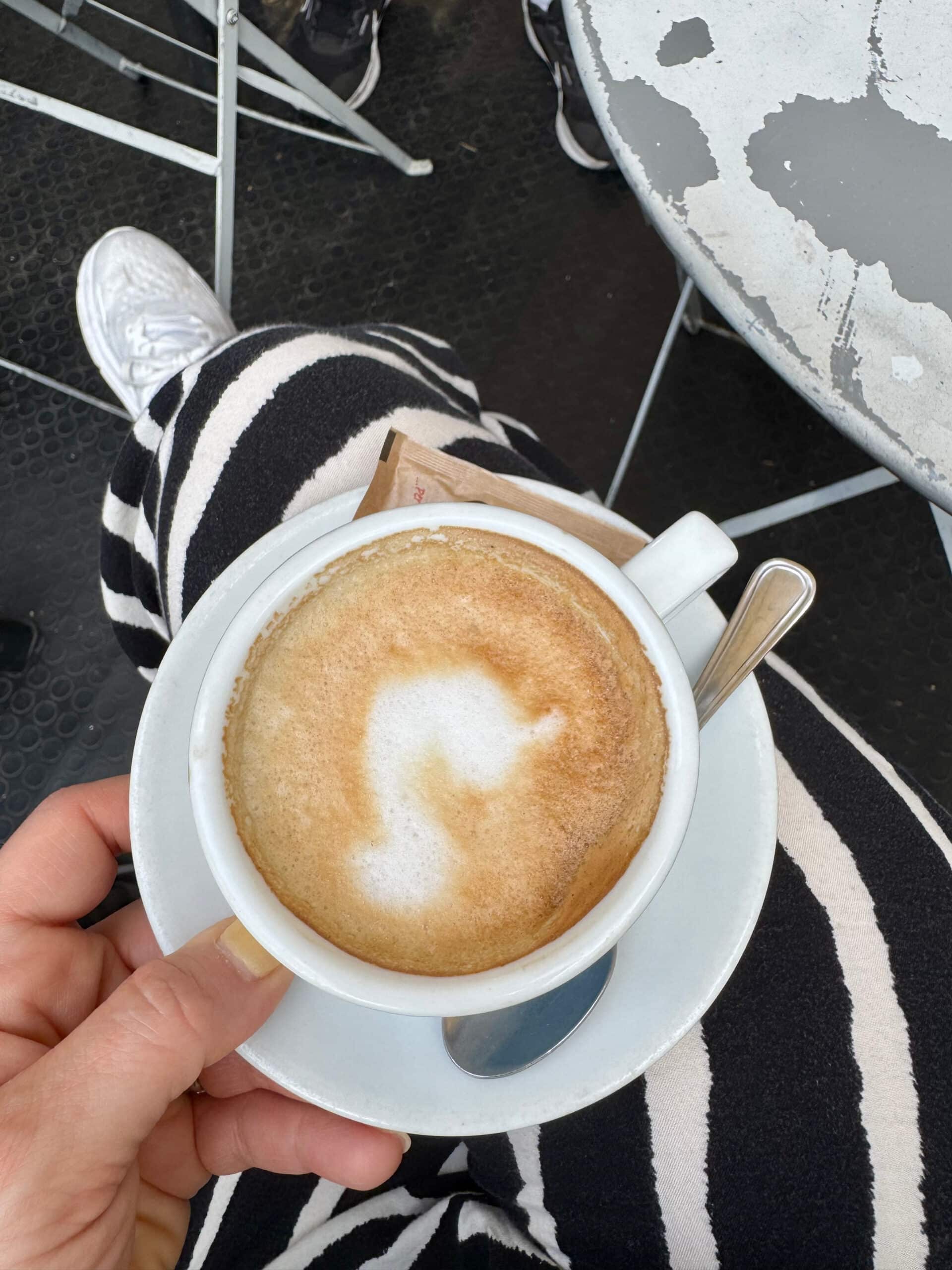 Liz holding a mug of espresso in her lap.