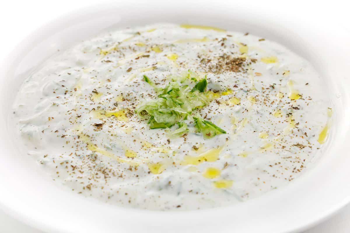 Chilled cucumber yogurt soup in a shallow white bowl.