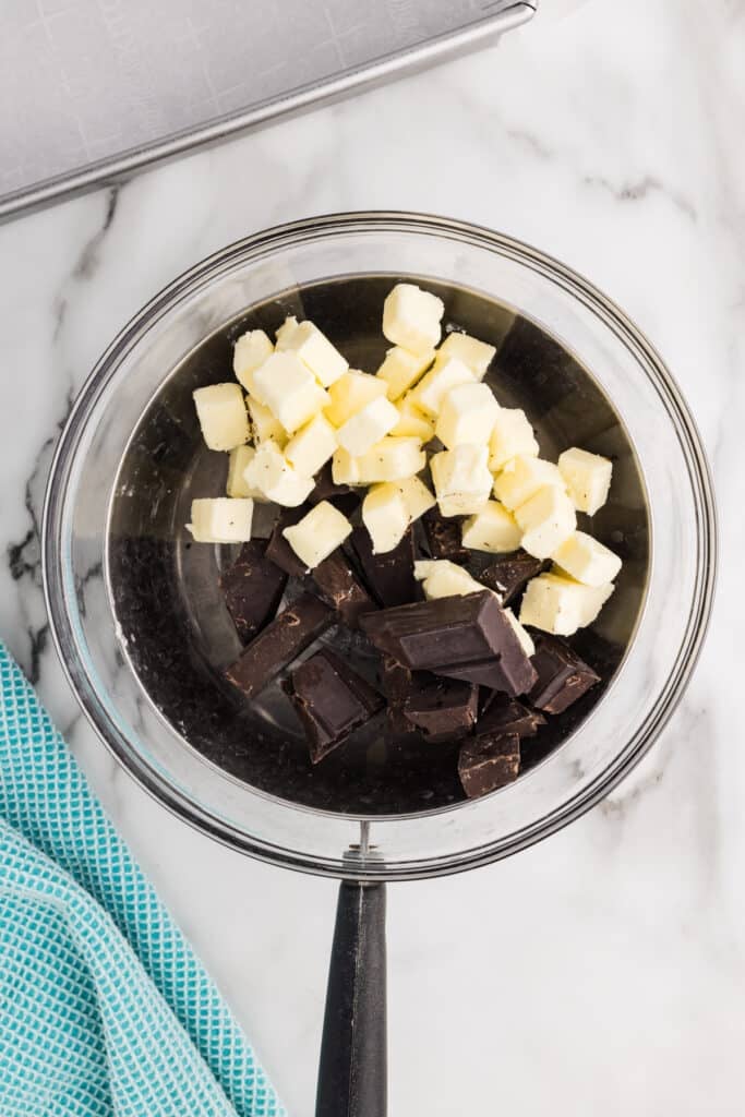 Glass bowl with cubed butter and chunks of chocolate.