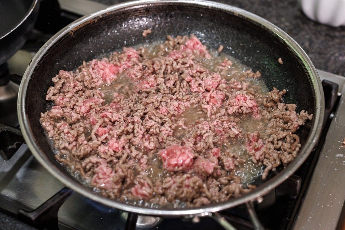 Cooking ground lamb in a skillet.