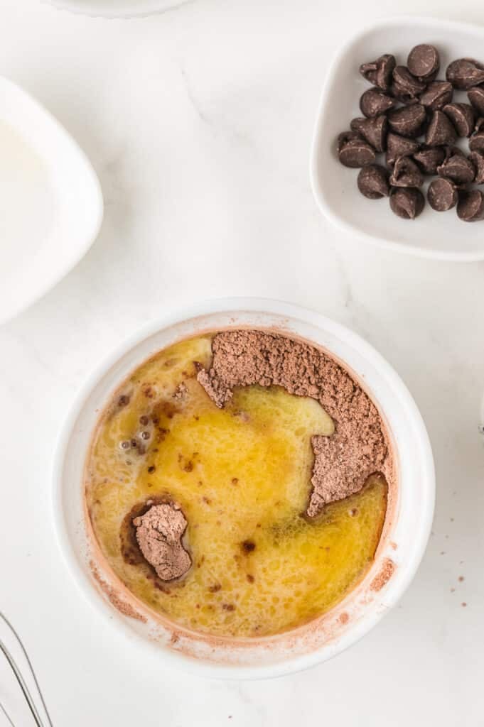 Brownie mix with melted butter and wet ingredients in a white ramekin.