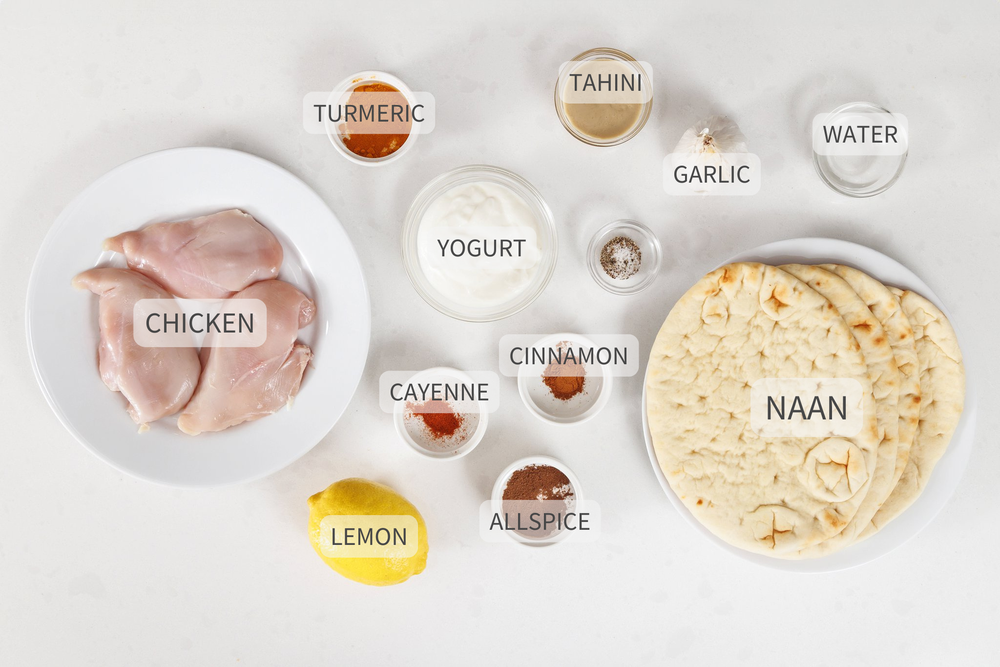Labeled ingredients for chicken shawarma naan wraps on a white counter.