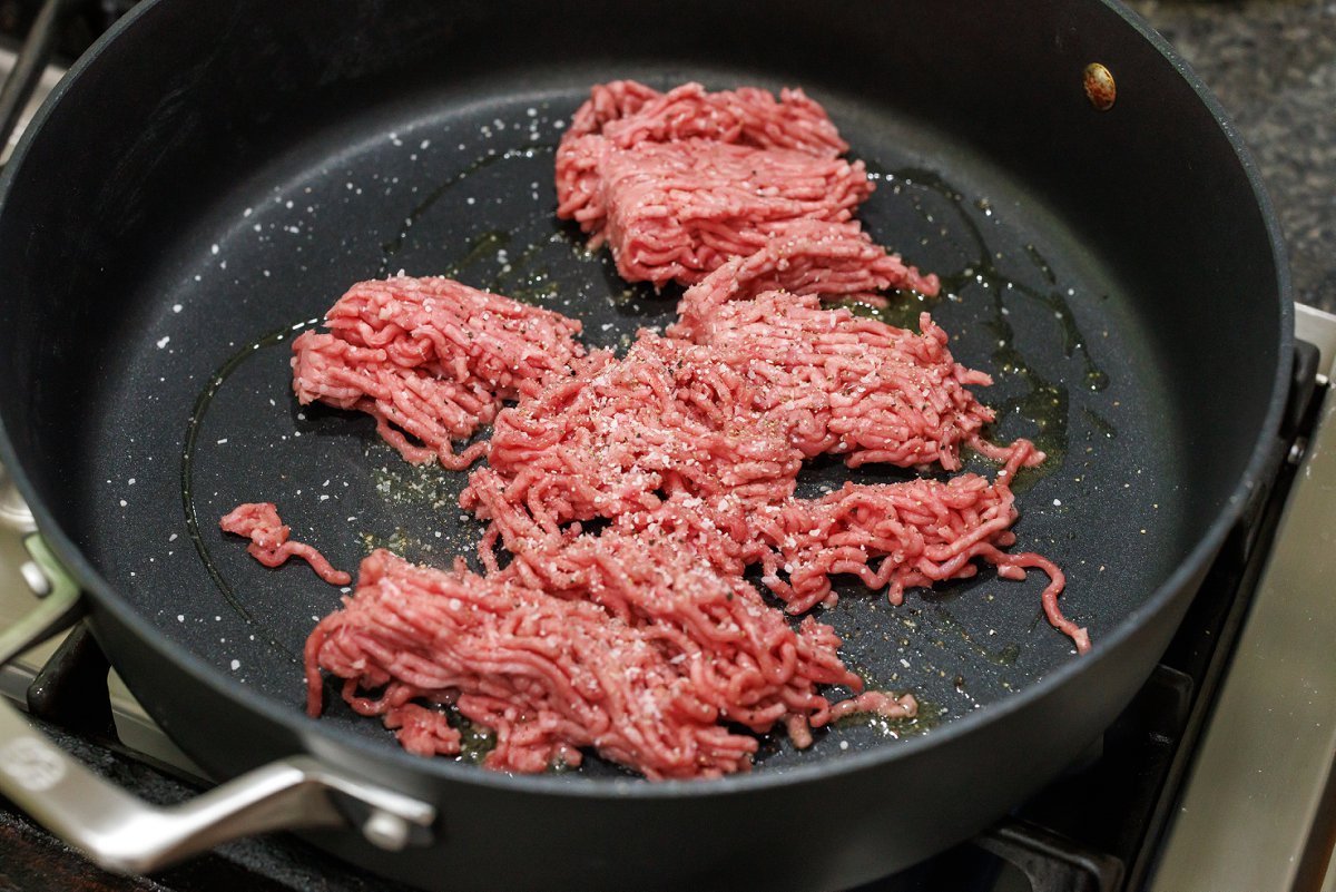 Cooking ground lamb in large skillet.
