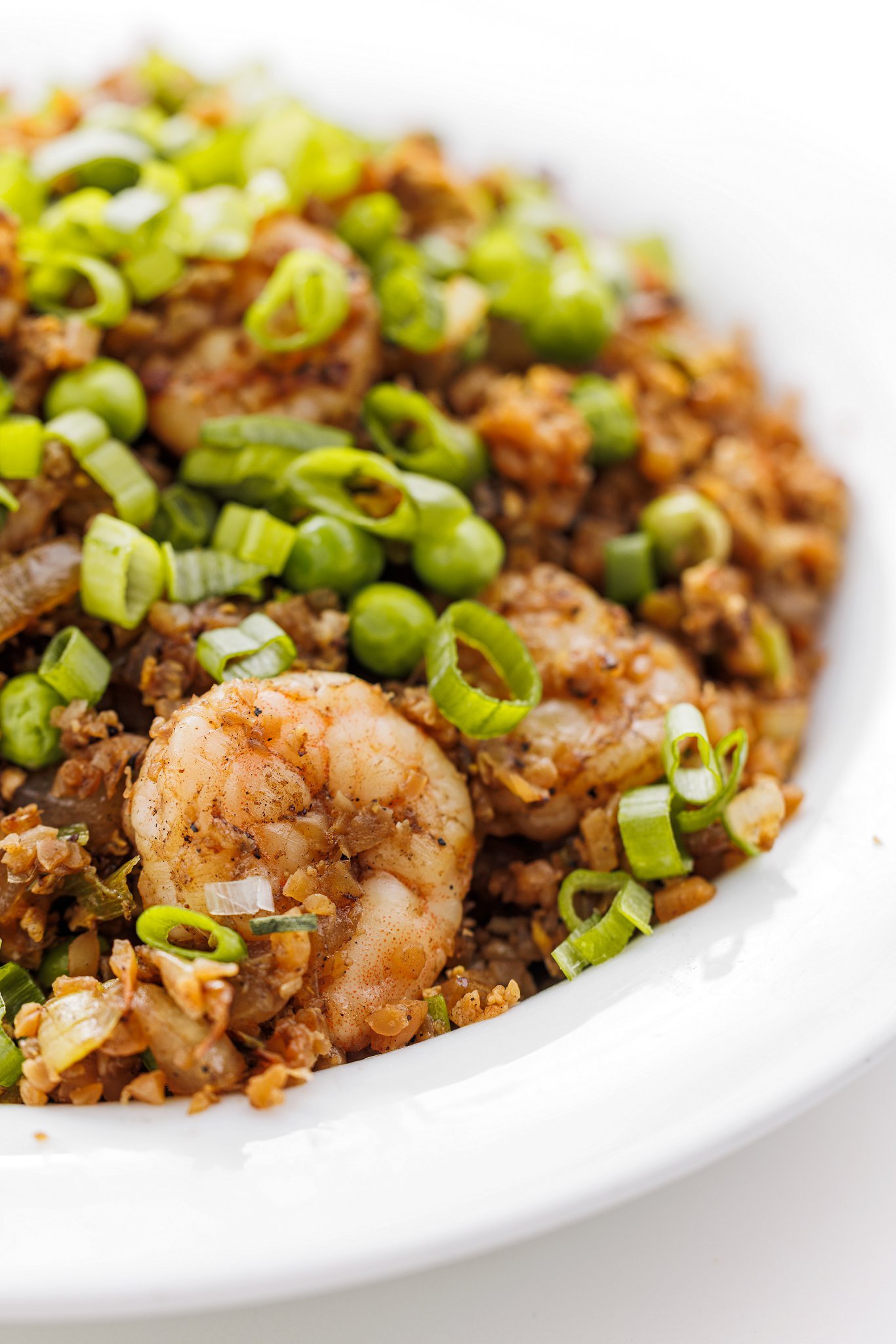 Shrimp fried cauliflower rice garnished with fresh scallions.