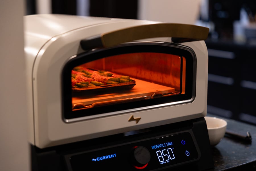 Pizza baking in a Curretn Backyard pizza oven.