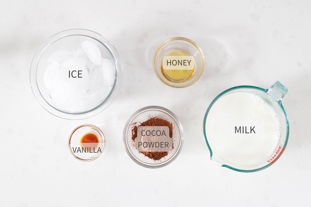 Labeled ingredients for frozen hot chocolate on a white counter top.