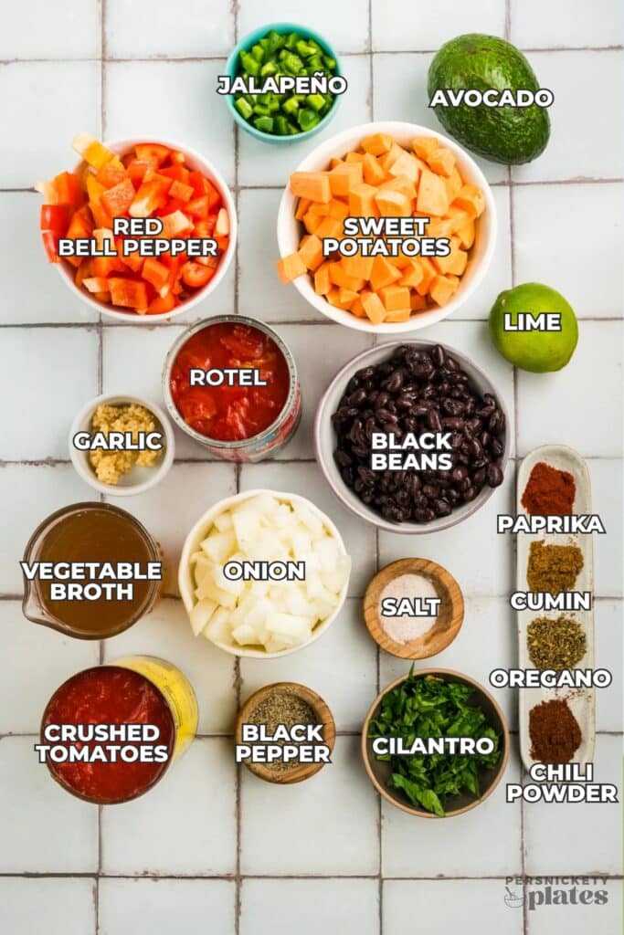 Labeled ingredients for chili arranged on a tiled surface.
