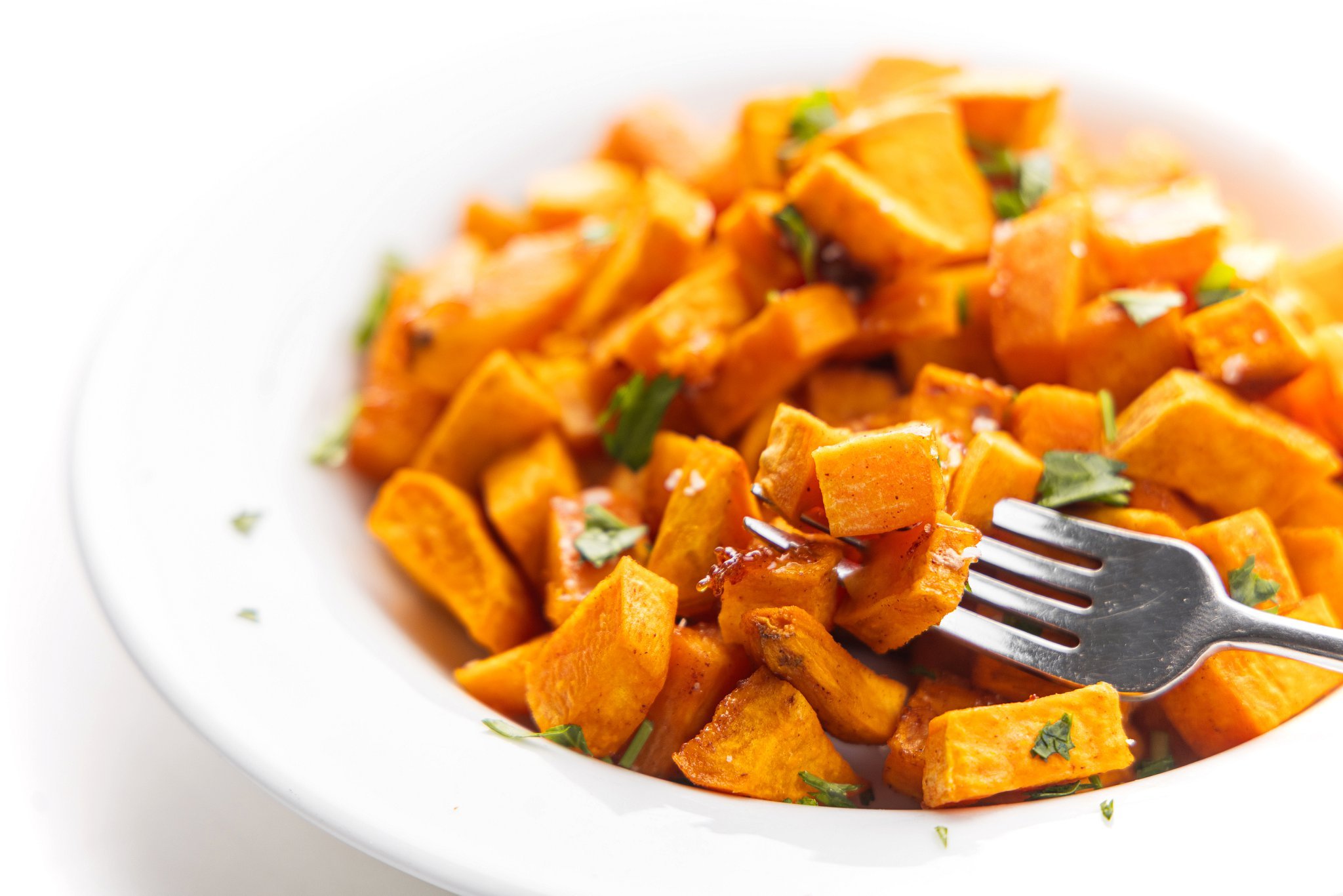 Roasted salted maple sweet potatoes in a bowl with a fork.