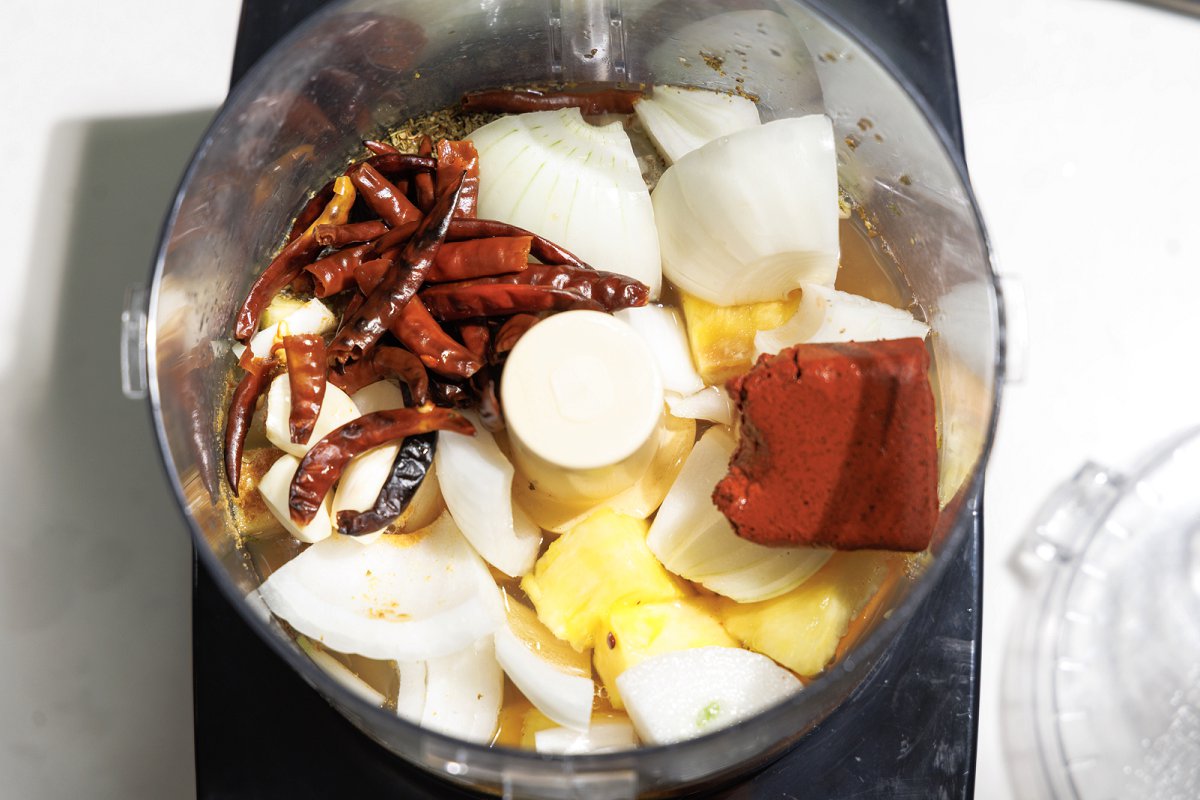 Onion, spices, and dried chiles in a food processor.
