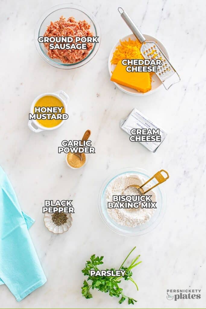 A flat lay of labeled ingredients for making sausage balls with cream cheese, arranged neatly on a marble counter.