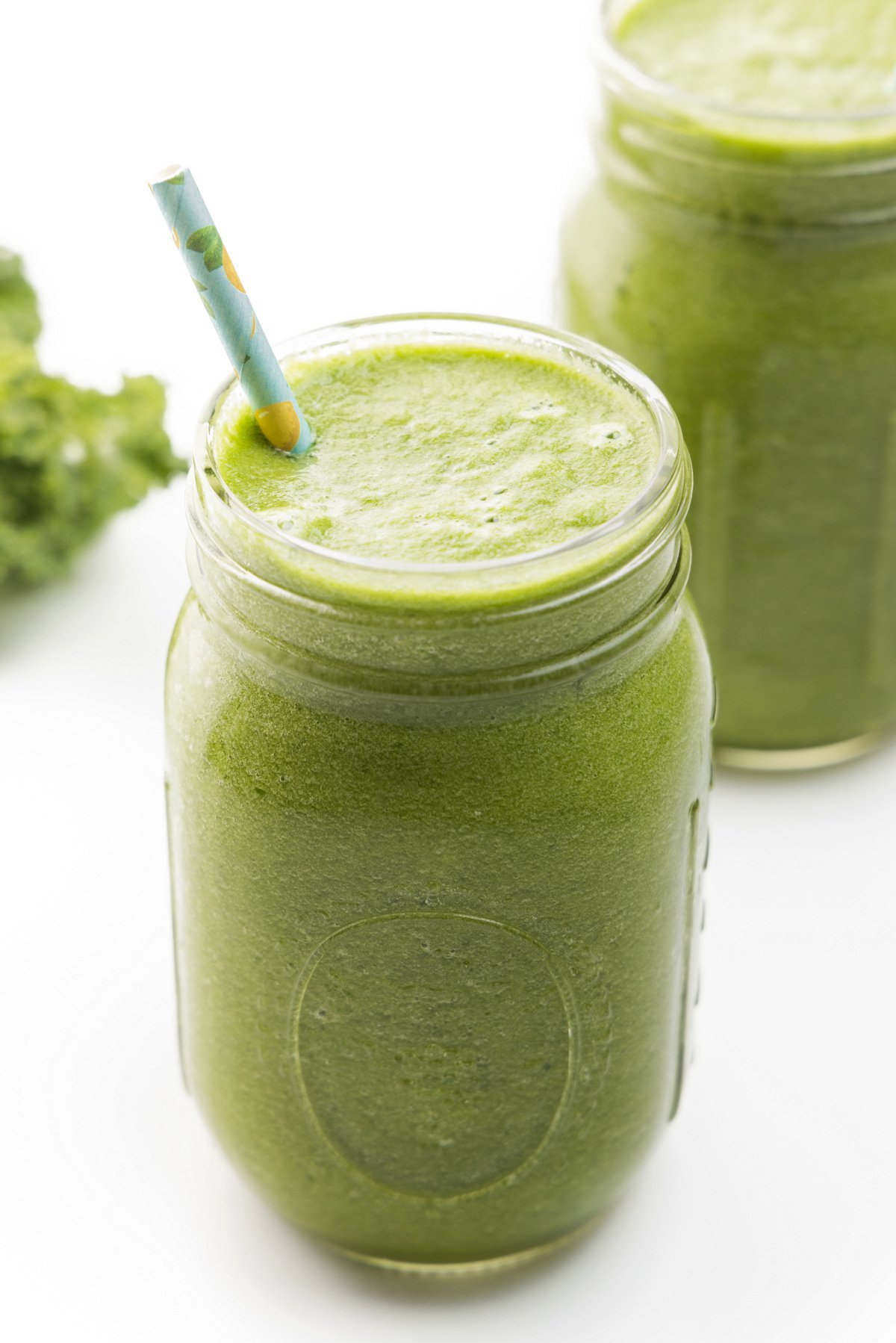 Kale, pear, and peach green juice in a mason jar glass.
