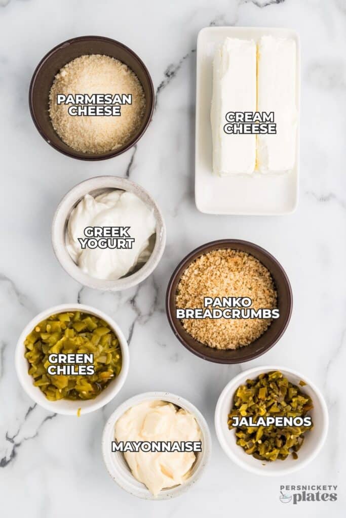 Ingredients for jalapeño popper dip labeled on a marble surface.