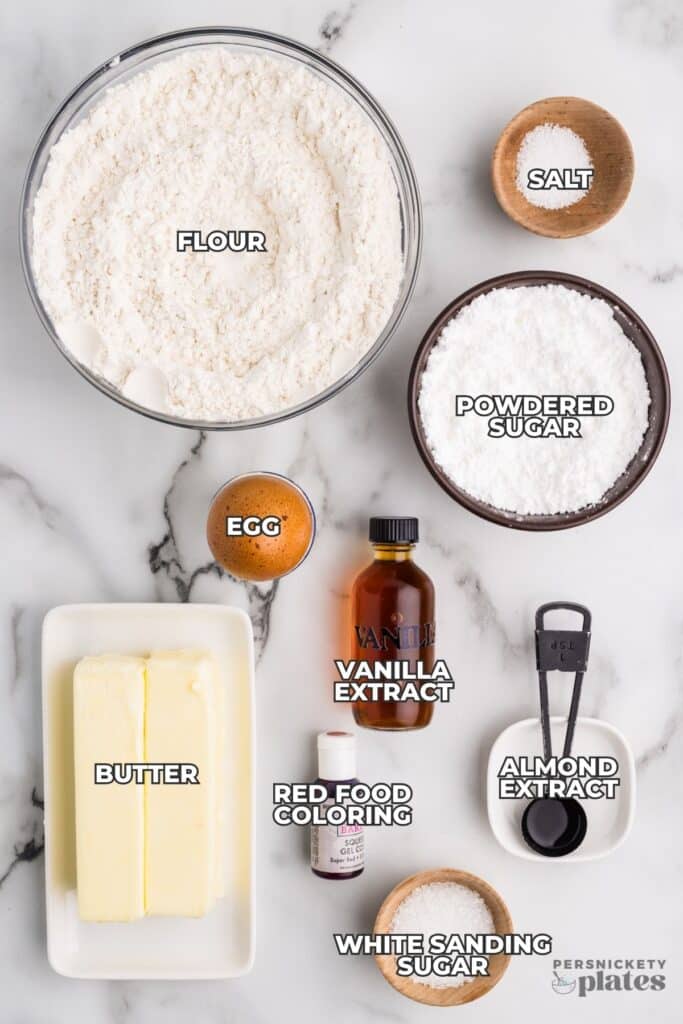 Labeled baking ingredients on a marble surface.