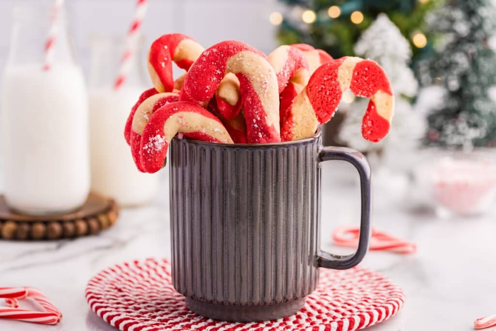 Candy cane cookies standing upright in a mug.